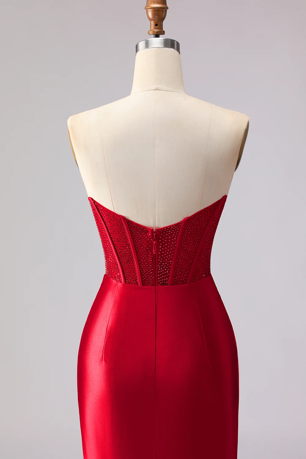 Glamuroso vestido de noche rojo corte sirena con corpiño de pedrería y abertura con volantes