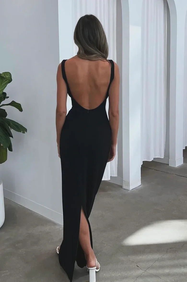 Vestido de noche negro con espalda descubierta, mangas casquillo y silueta hasta el suelo