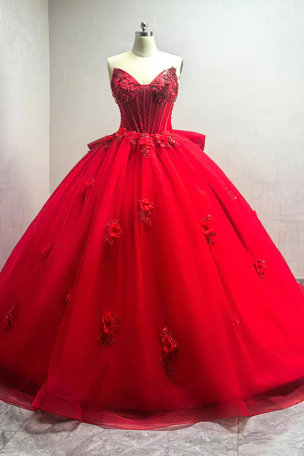 Vestido de graduación rojo de corte princesa con corpiño tipo corsé de pedrería y apliques florales