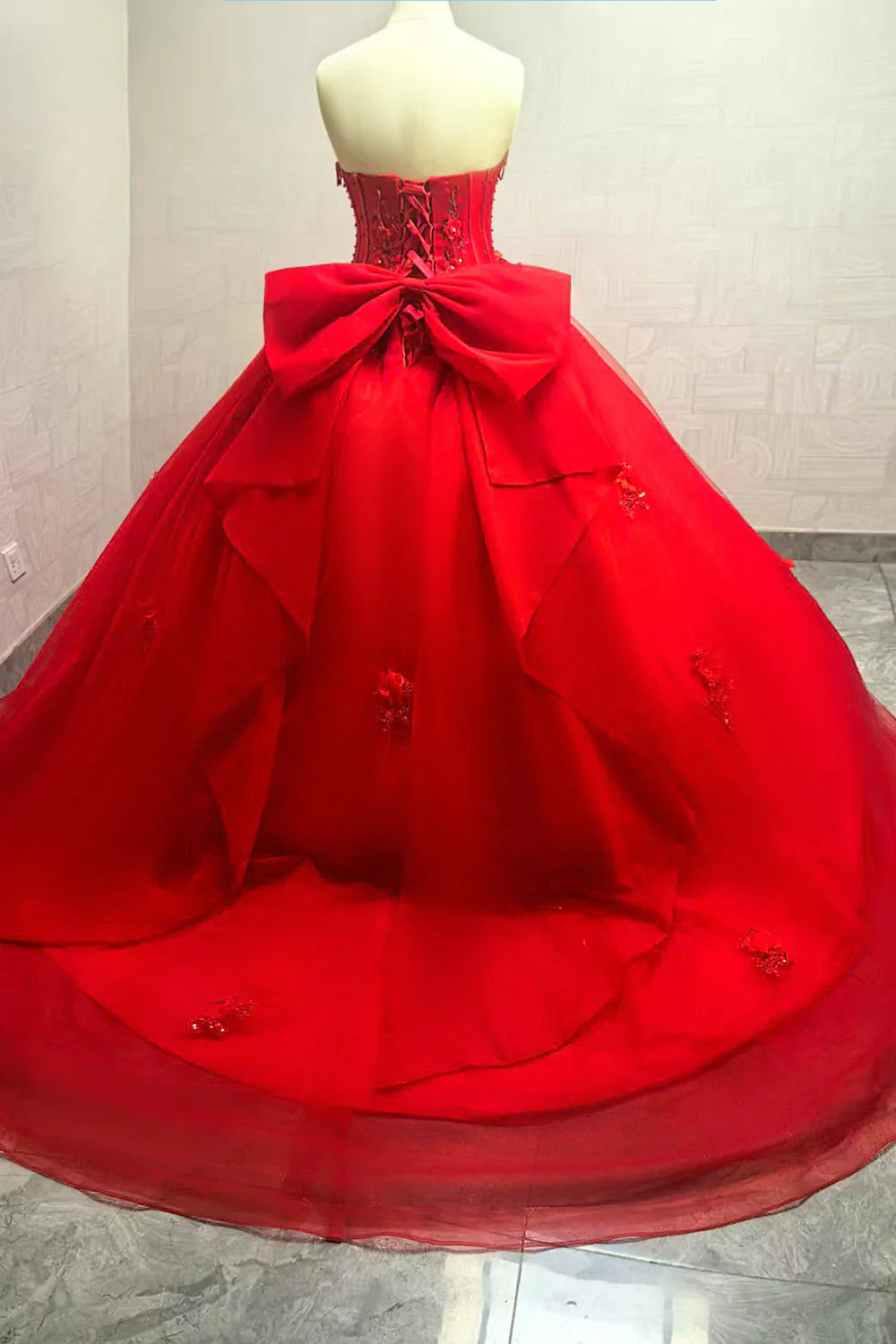 Vestido de graduación rojo de corte princesa con corpiño tipo corsé de pedrería y apliques florales