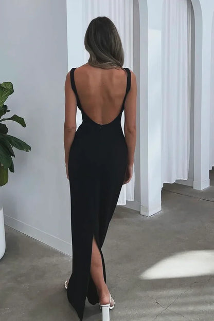 Vestido de noche negro con espalda descubierta, mangas casquillo y silueta hasta el suelo