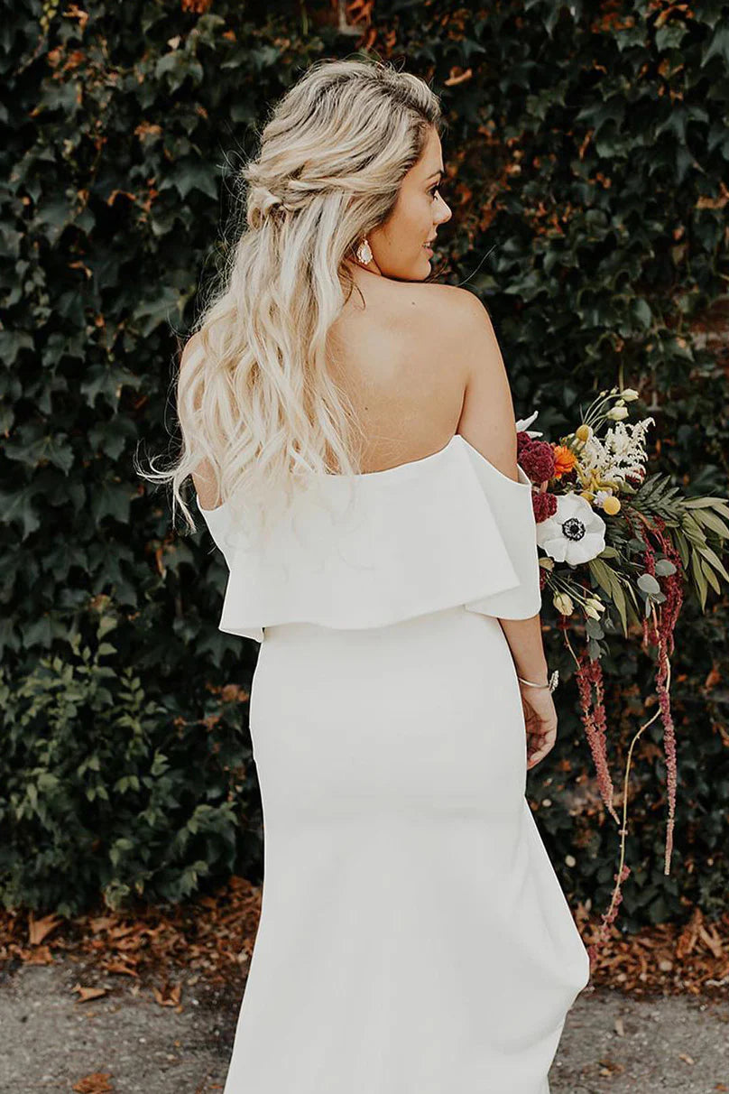Vestido de novia con hombros descubiertos, corpiño de volantes, abertura alta y cola de tul desmontable