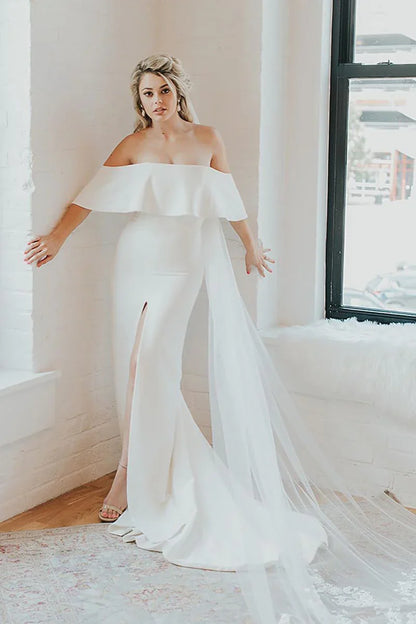 Vestido de novia con hombros descubiertos, corpiño de volantes, abertura alta y cola de tul desmontable