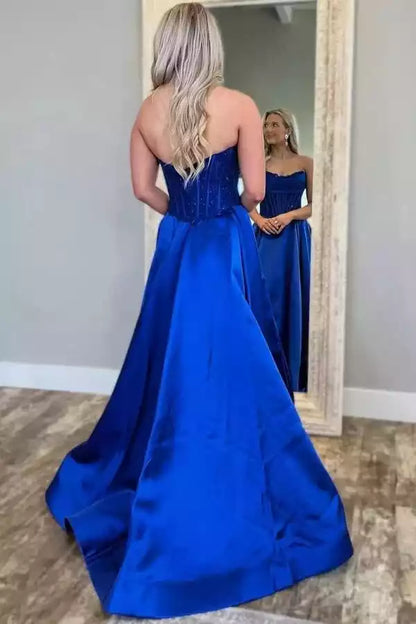 Robe de bal en satin bleu roi avec corsage corset sans bretelles et traîne.