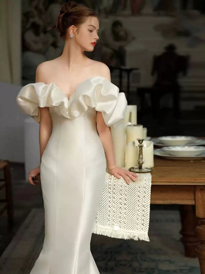 Romántico vestido de novia de satén corte sirena extragrande con hombros descubiertos, volantes, cola con pedrería y espalda baja