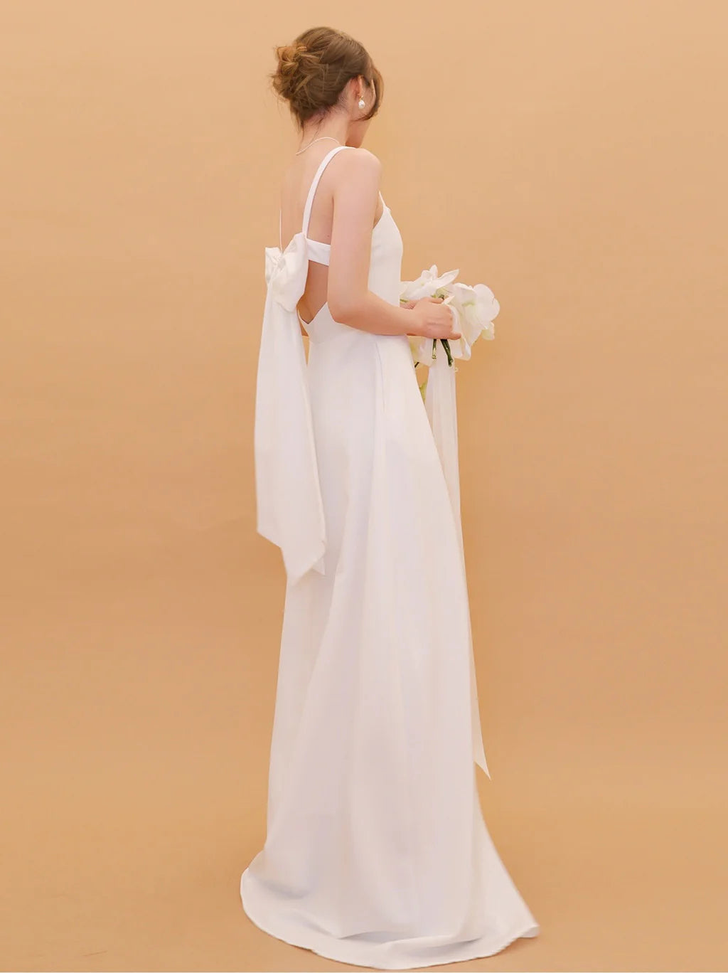 Vestido de novia de satén con escote cuadrado, tirantes finos, lazo extragrande en la espalda, falda en línea A y cola capilla