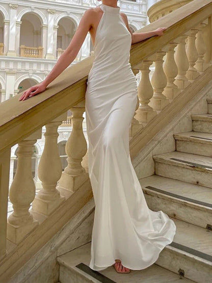 Elegante vestido de novia de satén con cuello halter, corte sirena, espalda abierta con lazo y cola larga