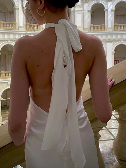 Elegante vestido de novia de satén con cuello halter, corte sirena, espalda abierta con lazo y cola larga